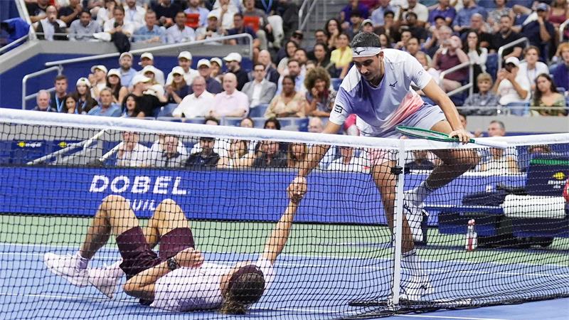 Lorenzo Sonego (r) hilft Zverev nach einem Strauchler wieder auf die Beine. 