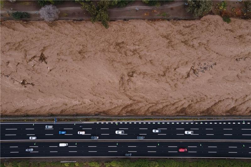 Überschwemmungen durch Unwetter in Chile - Tote Luftaufnahme des Mapocho-Flusses in Chile voller Wasser und mit starker Strömung, inmitten eines intensiven Regens.