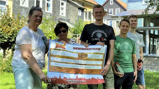 Luise Schrader (l.) und Sabine Krause nehmen den Scheck von drei der fünf Teilnehmer entgegen.