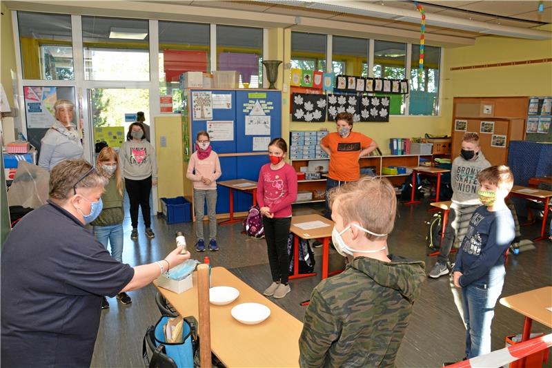 Lydia Fricke (li.) streut Pfeffer in die mit Wasser gefüllten Schalen. Die Viertklässler der Grundschule Hornburg schauen zu.  Foto: DRK