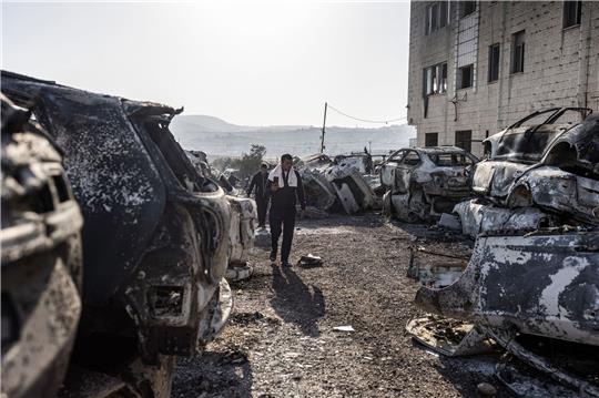 Männer gehen in Huwara an verbrannten und zerstörten Fahrzeugen vorbei. Nach einem tödlichen Anschlag auf zwei Israelis war es dort zu schweren Ausschreitungen israelischer Siedler gekommen.