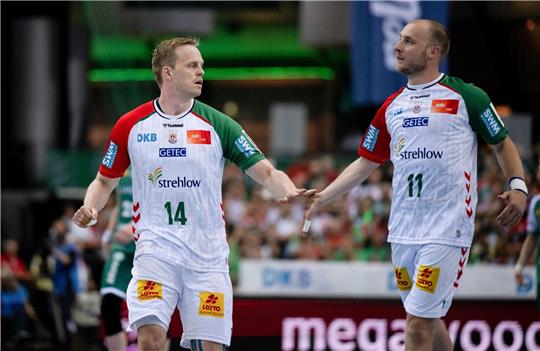 Magdeburgs Omar Ingi Magnusson (l) und Daniel Pettersson schlagen nach einem Tor ab.