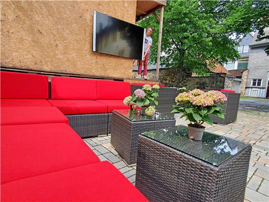 Maik Jankowsky, Gastronomieleiter im Hotel „Alte Münze“, positioniert schon einmal den Fernseher im Garten der Herberge.  Foto: Sowa
