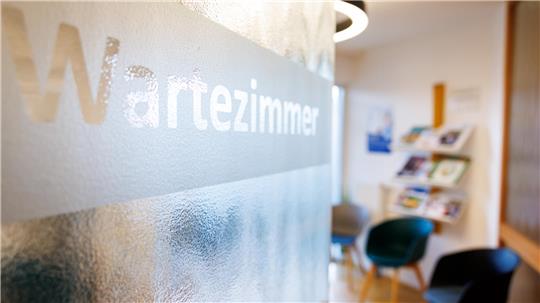 Die Tür zu einem Wartezimmer steht halb geöffnet.