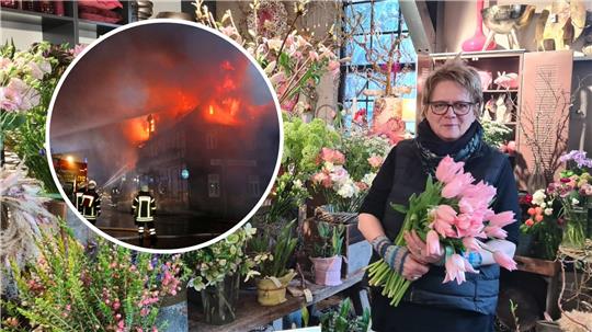 Eine Frau mit Brille hält einen dicken Strauß mit rosa Tulpen im Arm, um sie herum zahlreiche Blumen in einem Blumengeschäft.