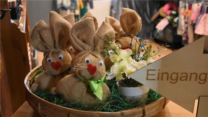 Eine Schüssel mit Osterhasen aus Sackstoff und mit roten Herz-Nasen steht im Eingang zu einem Warenraum.