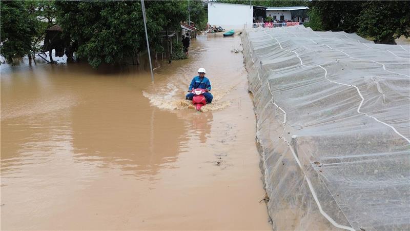 Mann kämpft sich auf überfluteter Straße durch die Fluten in Zentralvietnam