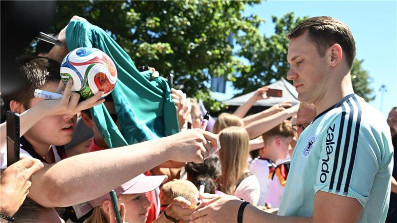 Manuel Neuer schreibt Autogramme. 