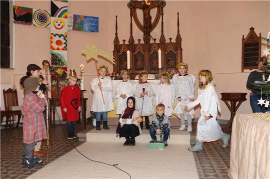Maria und Josef (Mitte) mit dem Jesuskind und den Hirten im Stall. Im Schladener Krippenspiel geht ein kleiner Engel (rechts) zunächst bei der Suche nach dem Christkind verloren und fragt sich durch, bis er es schließlich auch zum Stall schafft. Foto: Jambrek