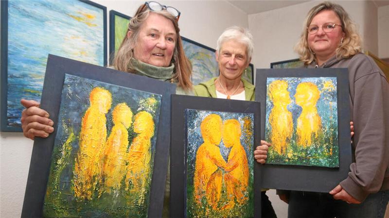 Marianne Zingler (li.) präsentiert gemeinsam mit Sabine Krause und Andrea Boos (re.) die drei Bilder, die zusammen den Titel „Wir“ tragen – es ist auch das Motto der Schau.