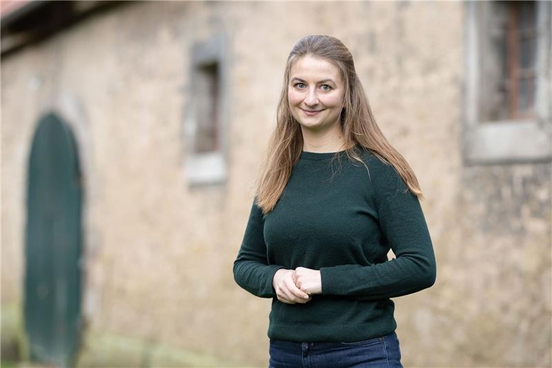 Marie von Schnehen, Landwirtin, steht vor einer Scheune.