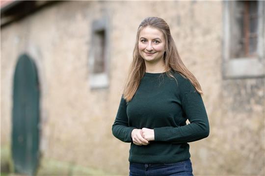 Marie von Schnehen, Landwirtin, steht vor einer Scheune.