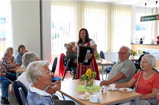 Marina Hein unterhält Gäste der 50-Jahr-Feier beim Harzklub-Zweigverein Hahausen mit ihrer Musik, und viele singen freudig mit. Da muss der Kuchen eben einen Moment stehen bleiben ... Fotos: Leifeld