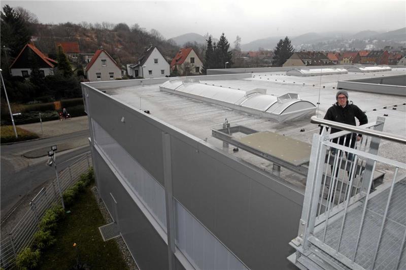 Mario Schmidt, Leiter Marketing und Vertrieb im Luftfahrtmuseum, zeigt auf dem Dach die Podeste, auf dem die Transall gute zehn Meter über der Straße stehen soll. Im Hintergrund erhebt sich der Agnesberg mit dem Wernigeröder Schloss.