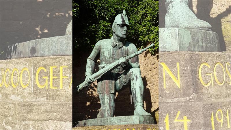 Bronzestatue eines Soldaten mit Helm und Gewehr, der mit einem Knie auf einem Sockel kniet