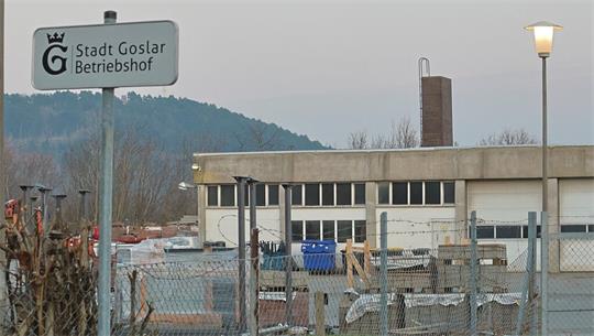 Gelände mit Zaun, im Hintergrund ein Gebäude und ein Schild mit der Aufschrift 'Stadt Goslar Betriebshof' bei Dämmerung