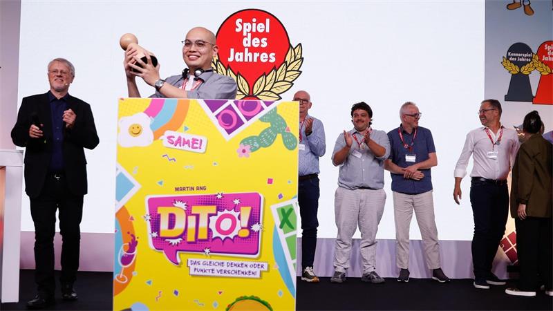 Martin Ang, Gewinner des „Spiel des Jahres 2026“ mit dem Spiel „Dito“, jubelt während der Verleihung im nhow Hotel Berlin.
