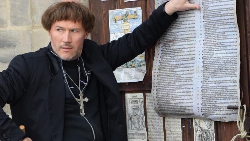 Ein Lexikon zum Reformationstag Martin Luther schlägt seine 95 Thesen an die Pforte der Schlosskirche in Wittenberg: Die Szene mit Schauspieler Christian Nickel entstand bei den Dreharbeiten 2017 am Originalschauplatz für das Theaterstück „Der Anschlag“ bei den Bad Hersfelder Festspielen.
