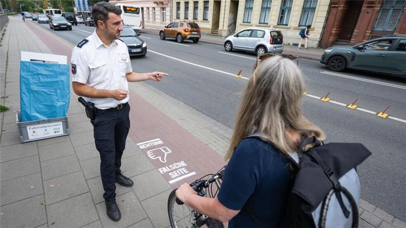 „Sei kein Geist!“ - Aktion gegen Fahrradunfälle in Lüneburg Martin Schwanitz, Verkehrssicherheitsberater bei der Polizei, weist eine Fahrradfahrerin in einer gestellten Szene darauf hin, dass sie die falsche Straßenseite nutzt.