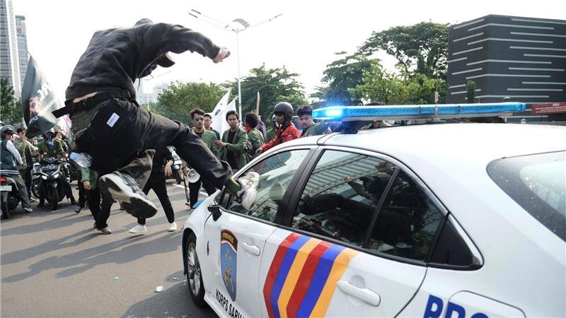 Massenproteste gegen die Regierung in Indonesien: ein Demonstrant attackiert ein Polizeiauto.