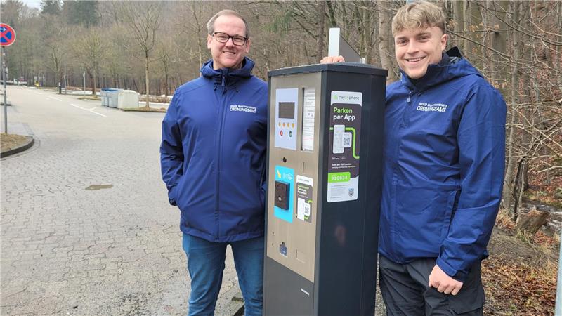Maximilian Schneider (l.) und Johannes Kappe präsentieren einen der beiden neuen Parkscheinautomaten am Großparkplatz. Zu erkennen sind sie an der schwarzen Farbe, die alten Geräte sind weiß.