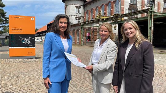 Das Bild zeigt links May-Britt Pürschel (l.), Referatsleiterin im niedersächsischen Wirtschaftsministerium, mit   Goslars Oberbürgermeisterin Urte Schwerdtner in der Mitte und die Welterbe-Stiftungsdirektorin Lea Dirks  rechts auf der Werksstraße am Rammelsberg.