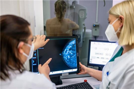 Medizinisches Personal untersucht mit einer Mammografie die Brust einer Frau auf Brustkrebs.
