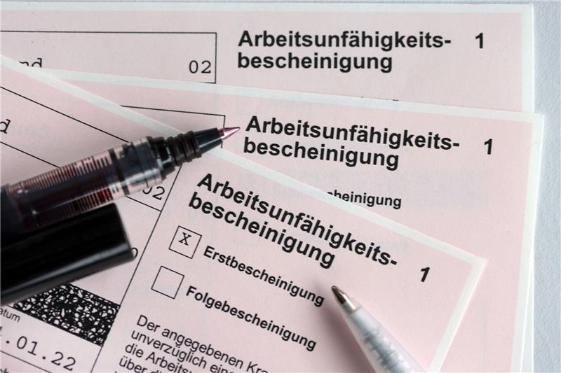 Krankenstand in Niedersachsen sinkt leicht Mehrere Arbeitsunfähigkeitsbescheinigungen liegen auf einem Tisch.