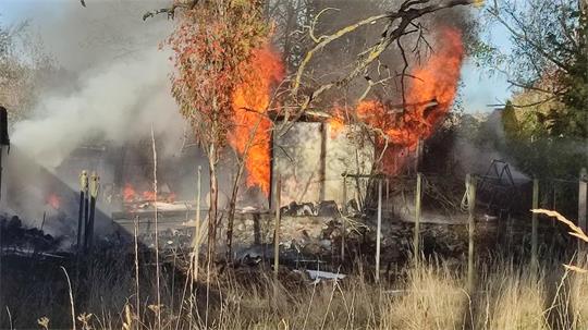 Eine Garage steht in Flammen. Drumherum sind Sträucher und Vegetation.