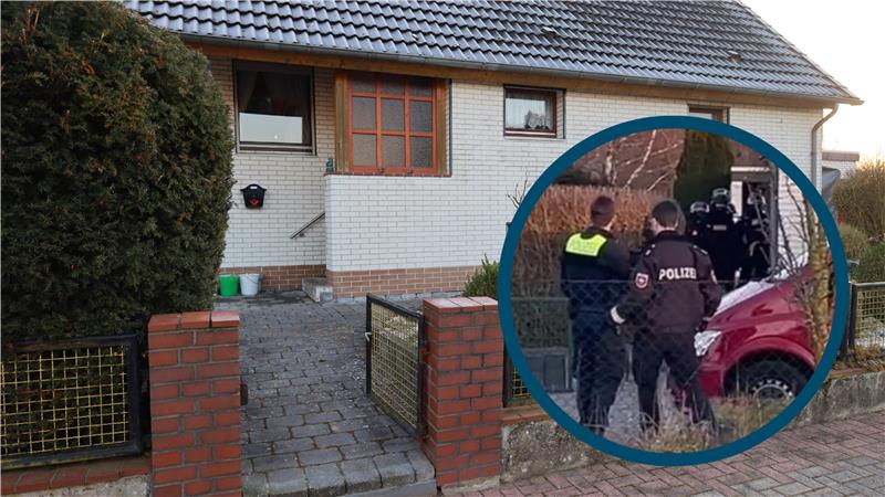 Vermummte Spezialkräfte stehen vor der Haustür eines Hauses. Davor stehen zwei Polizeibeamte.