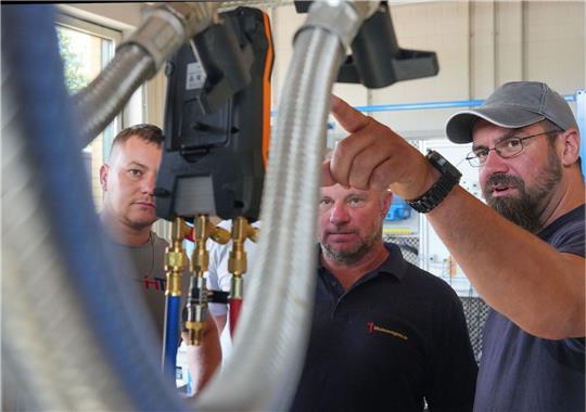 Meisterschüler Martin Scholz (r) unterhält sich mit Kollegen im Wärmepumpen-Labor auf dem Bildungs- und Innovationscampus der Handwerkskammer Potsdam (BIH).