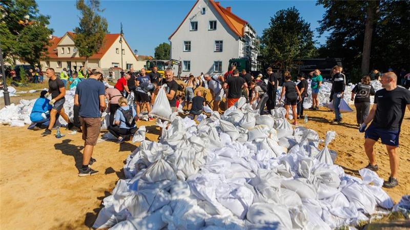 Hochwasserwelle bewegt sich in Polen flussabwärts Menschen arbeiten in Polen an der Verstärkung der Deiche.