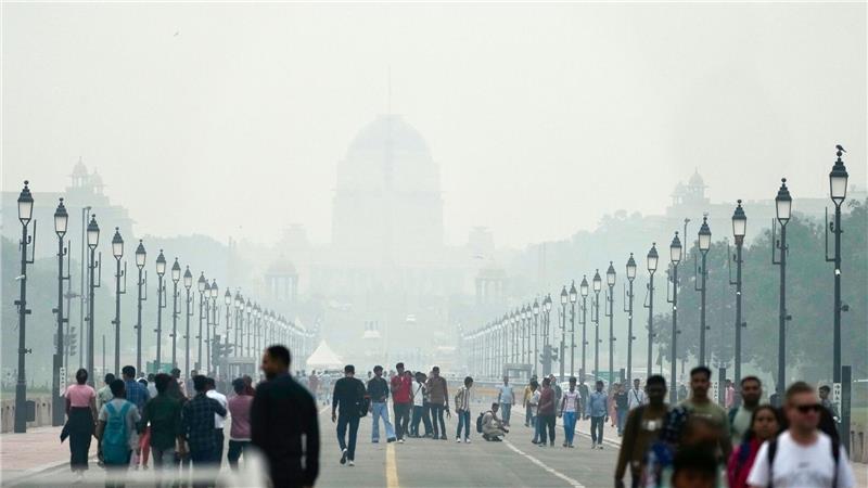 Menschen auf einer in Smog gehüllten Straße in Neu Delhi. (Archivbild)