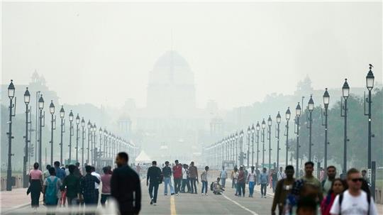 Menschen auf einer in Smog gehüllten Straße in Neu Delhi. (Archivbild)