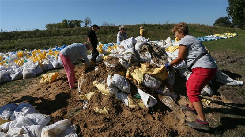 Hochwasserwelle bewegt sich in Polen flussabwärts Menschen bauen in Polen mit Sandsäcken Barrieren gegen das Hochwasser.