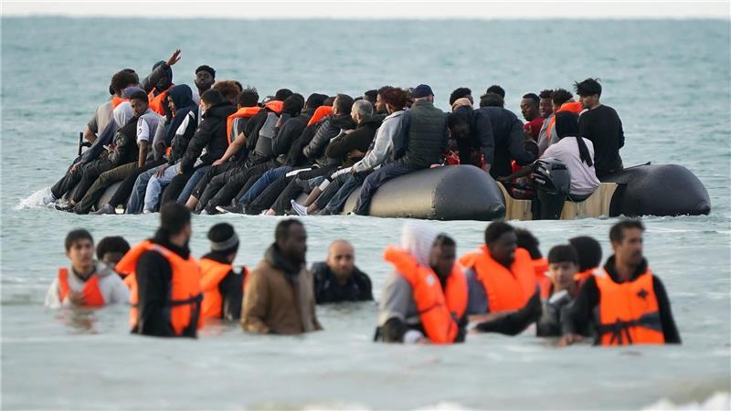 Menschen, bei denen es sich vermutlich um Migranten handelt, waten im Meer in Gravelines in Frankreich, nachdem sie erfolglos versucht hatten, an Bord eines kleinen Bootes zu gelangen.