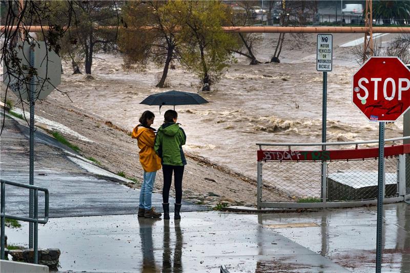 Präsident Biden erklärt für Kalifornien den Katastrophenfall Menschen beobachten die großen Mengen an Regenwasser im Los Angeles River.