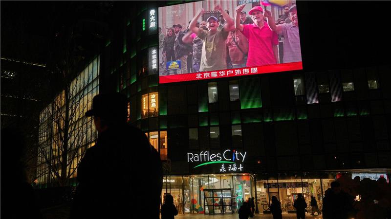 Menschen beobachten in China eine Übertragung einer Kundgebung aus Caracas.