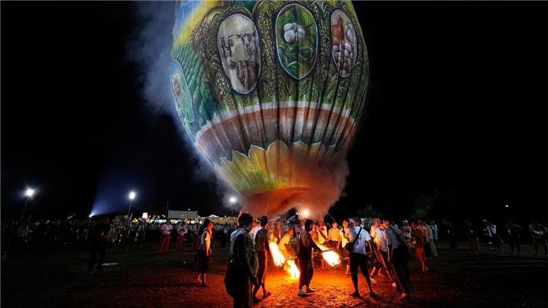 Menschen bereiten sich auf den Start eines Heißluftballons während eines Wettbewerbs anlässlich des Tazaungdaing-Fests in Naypyitaw in Myanmar vor.