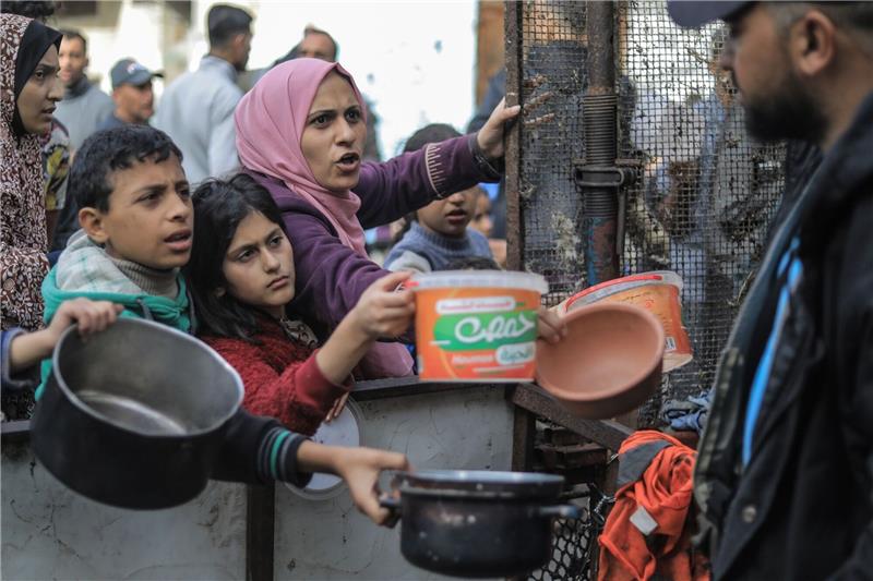 Hunger quält Menschen in Gaza - Israel sieht Hamas angezählt Menschen bitten an einer Essensausgabe in Rafah um Lebensmittel.