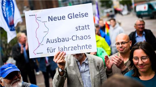 Menschen demonstrieren für den Neubau der Bahnstrecke Hamburg-Hannover. 