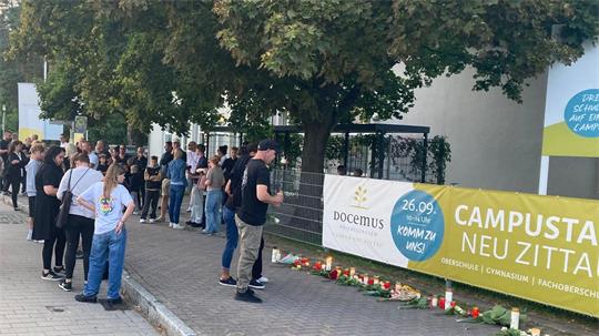 Menschen gedenken der zwei Toten in Neu Zittau. 