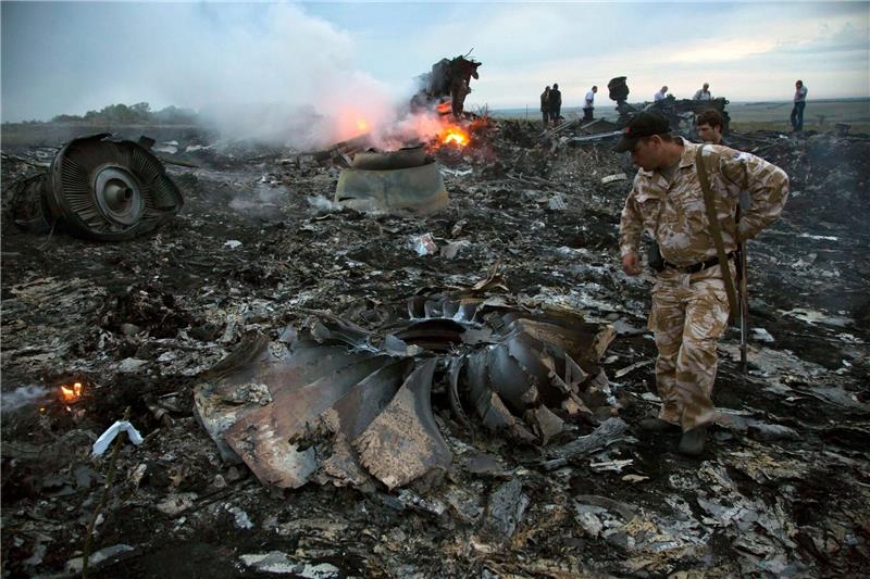 Ermittler: Putin hatte aktive Rolle bei MH17-Abschuss Menschen gehen durch die Trümmer an der Absturzstelle des Passagierflugzeugs MH17 in der Nähe des Dorfes Grabovo in der Ostukraine.