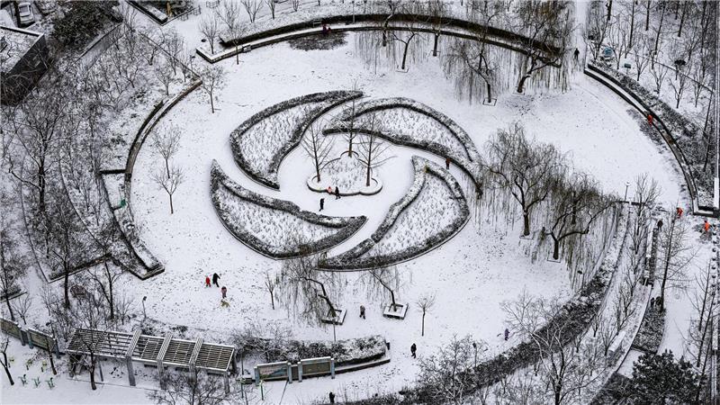 Menschen haben Spaß im Schnee in einem Park in Peking.