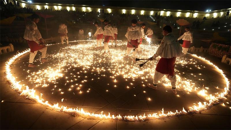 Menschen in traditioneller Tracht führen während der neuntägigen Feierlichkeiten des hinduistischen Festes Navratri in Ahmedabad in Indien den „Mashal Raas“ auf.