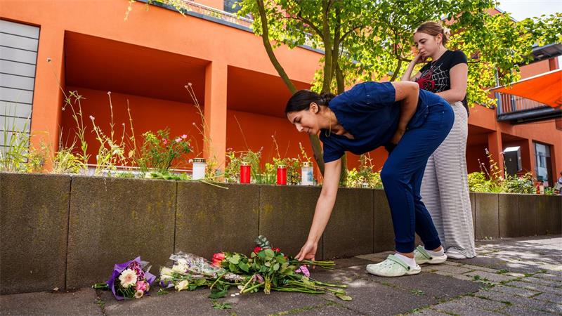 Menschen kommen vorbei und legen Blumen ab.