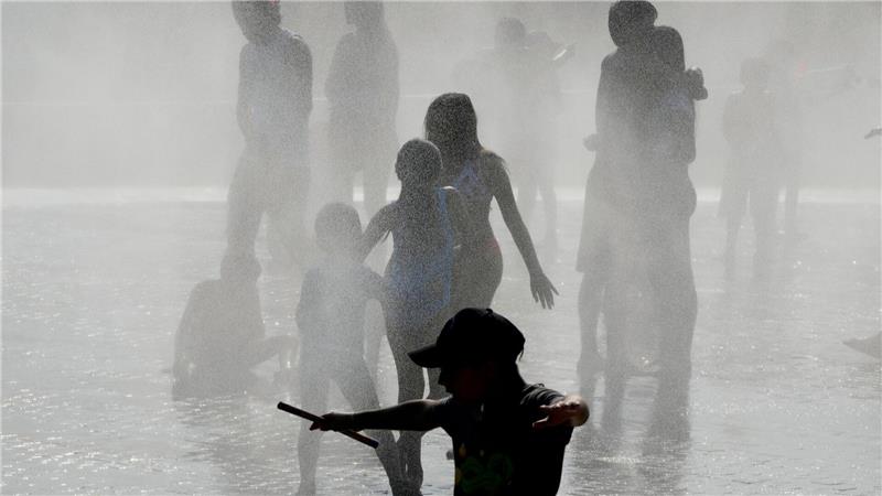 Bilder des Tages Menschen kühlen sich bei heißem Wetter in einem Brunnen in Madrid ab.