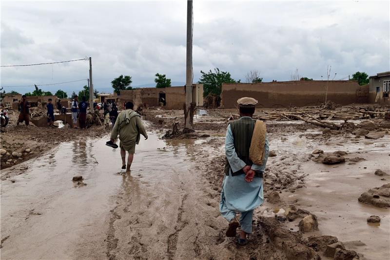 Mehr als 300 Tote bei Hochwasser in Afghanistan Menschen laufen über den von massiven Sturzfluten aufgeweichten Boden.