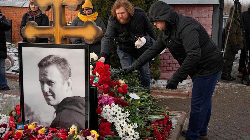 Menschen legen ein Jahr nach dem Tod des russischen Oppositionsführers Alexej Nawalny auf dem Borisowskoje-Friedhof in Moskau Blumen an seinem Grab nieder. 
