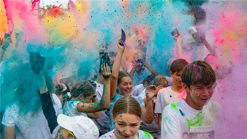 Menschen nehmen am Color Run in Jūrmala teil.Der 5 km lange Lauf findet im Kauguri-Park statt, wo die Teilnehmer mit Farbpulver und Schaum beworfen werden.
